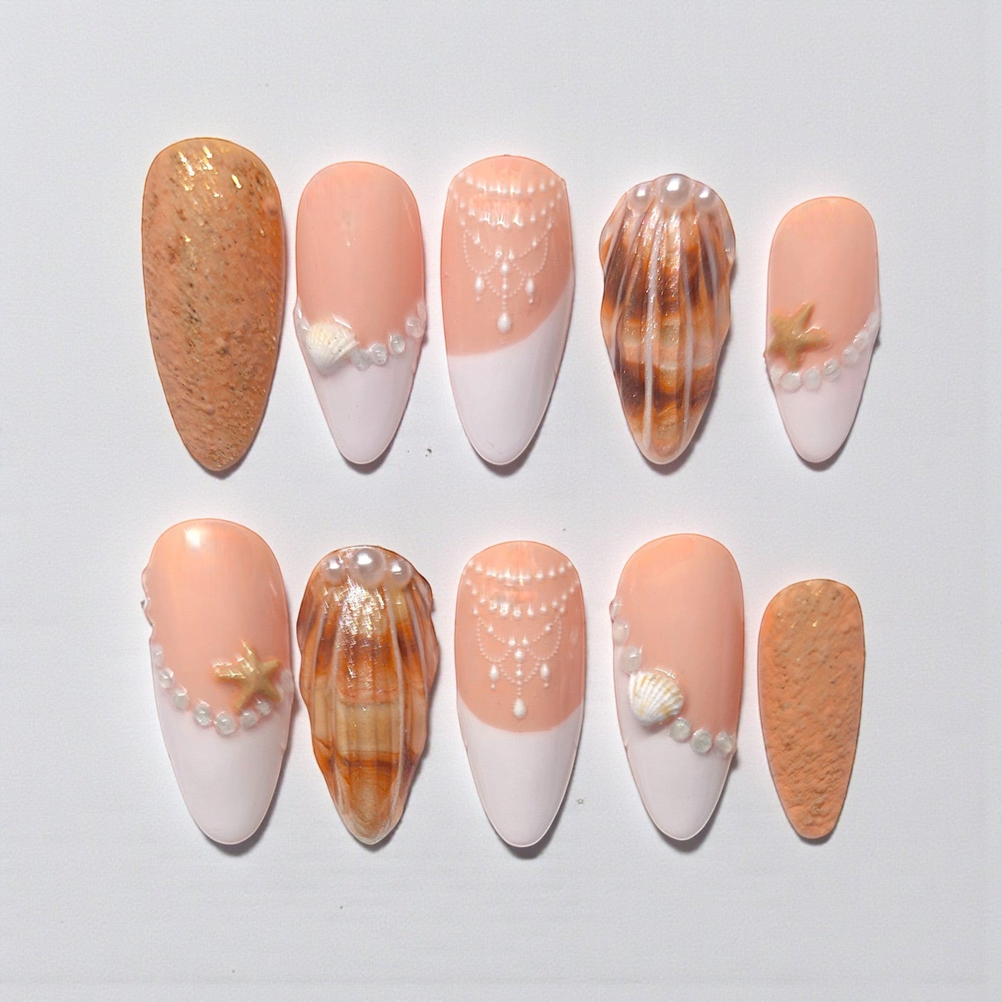 Auntie Cookies Nails: Set of 10 press-on nails with peach and white French tips, pearl and seashell accents, and sandy textured nails.