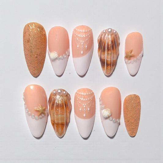 Auntie Cookies Nails: Set of 10 press-on nails with peach and white French tips, pearl and seashell accents, and sandy textured nails.