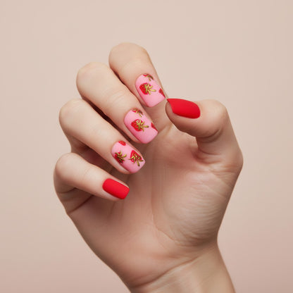 Auntie Cookies Nails matte pink press-on nails with red strawberry designs and solid red accent nails.