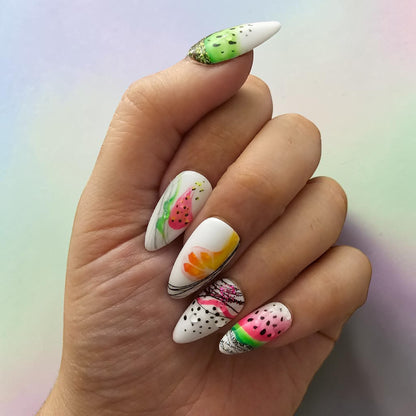 Auntie Cookies Nails: Stiletto press-on nails with vibrant fruit designs including watermelon, pineapple, and orange slices, plus glitter accents.